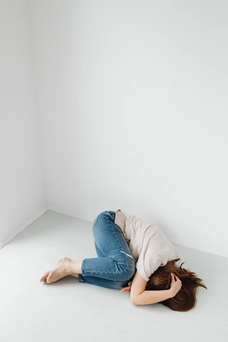 A person resting in a quiet, minimal room