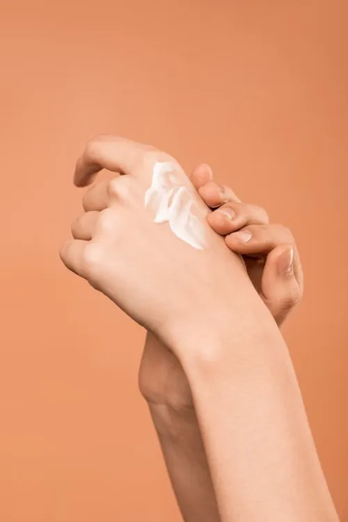 Hands applying a restorative cream